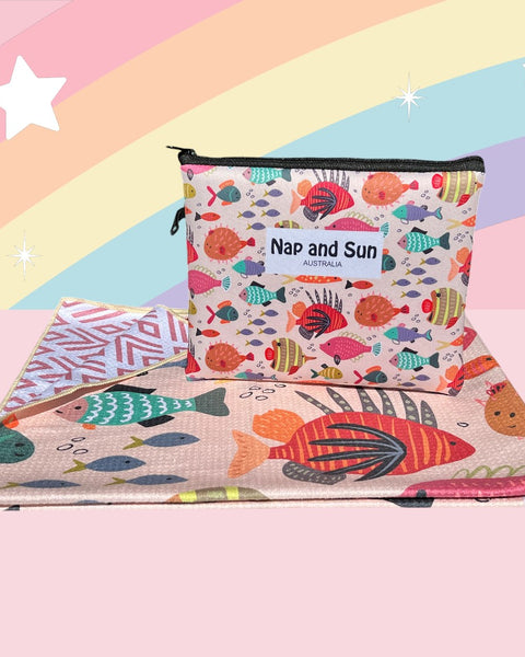 Nap and Sun Rainbow Reef sand-free beach towel for kids with a colorful underwater theme on the front, featuring vibrant coral, fish, and sea creatures on a light peachy background. Back: White background pink geometric lines. free matching wetbag included.