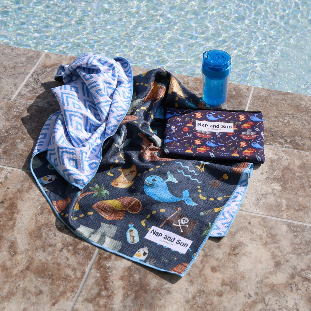 Blue, pirate, whale pattern children beach towel by the poolside with a wetbag