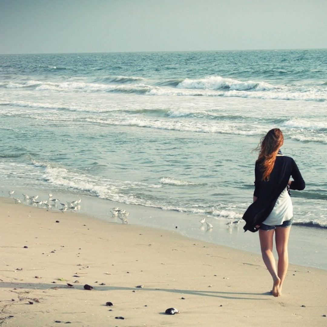 woman walking barefoot on a beach