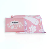 Nap and Sun Pink Bloom sand-free beach towel featuring a  soft pink background with white floral pattern. Free matching wetbag included.