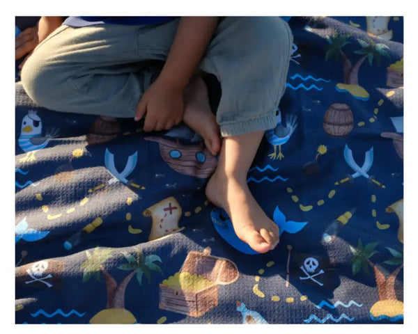 close up of a child sitting on a Pirate themed kids towel 