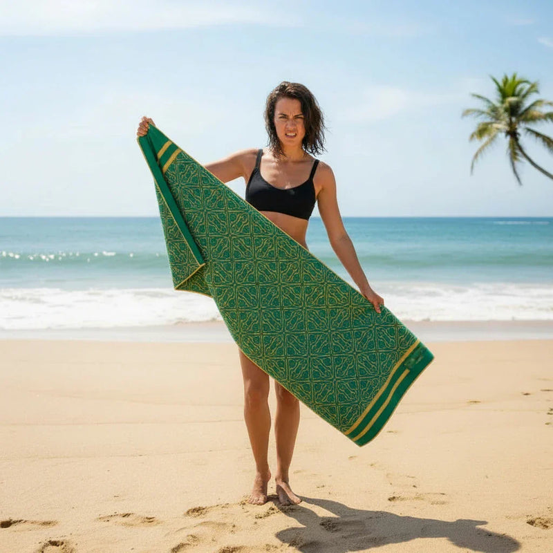 woman is holding a green towel on the beach, looks angry