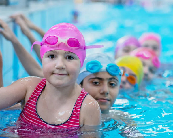kids in bright color swimsuits in a pool