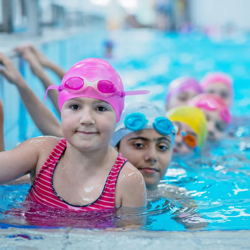 kids in bright color swimsuits in a pool