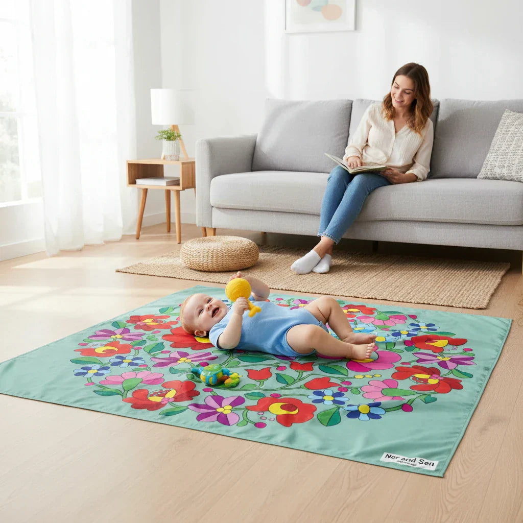 baby on a playmat in a living room with mum wathing him from the couch