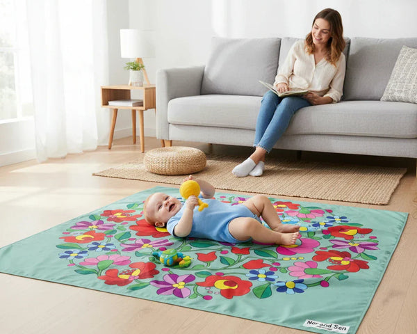 baby on a playmat in a living room with mum wathing him from the couch