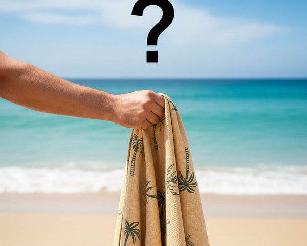 Hand holding a yellow beach towel on a beach with a question mark