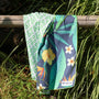 tropical pattern towel is hanging on a fence in a bush