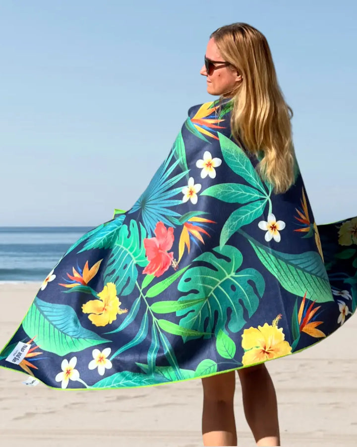 Woman wrapped in a tropical floral pattern sand-free beach towel