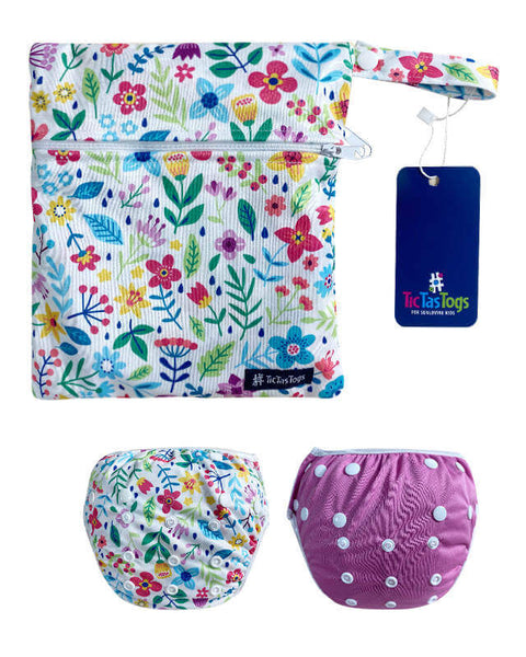 Floral-patterned diaper bag with two baby swim diapers on a white background