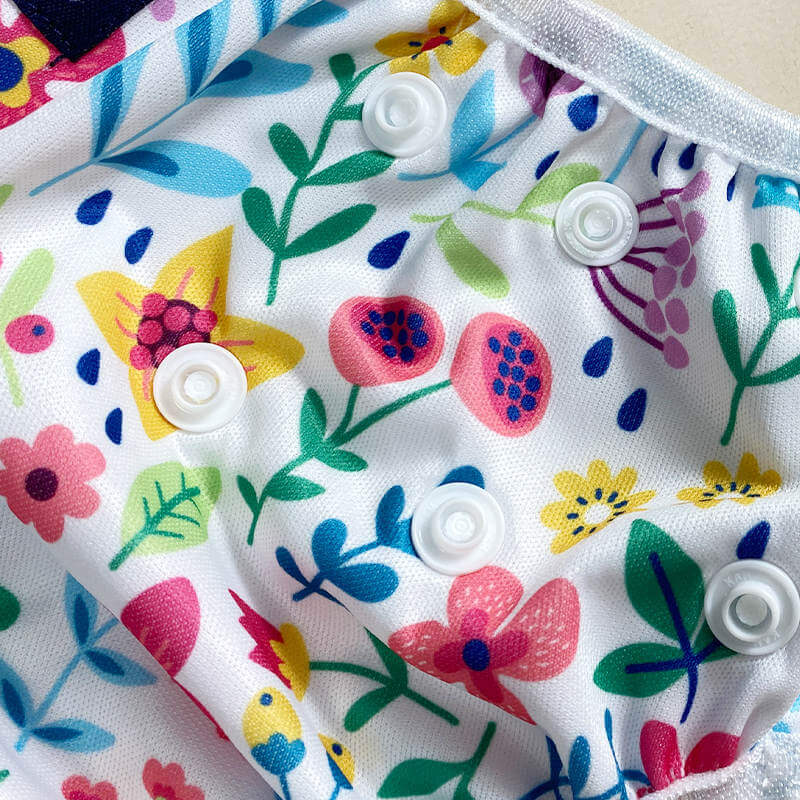 Colorful floral patterned swim nappy white buttons on a beige background