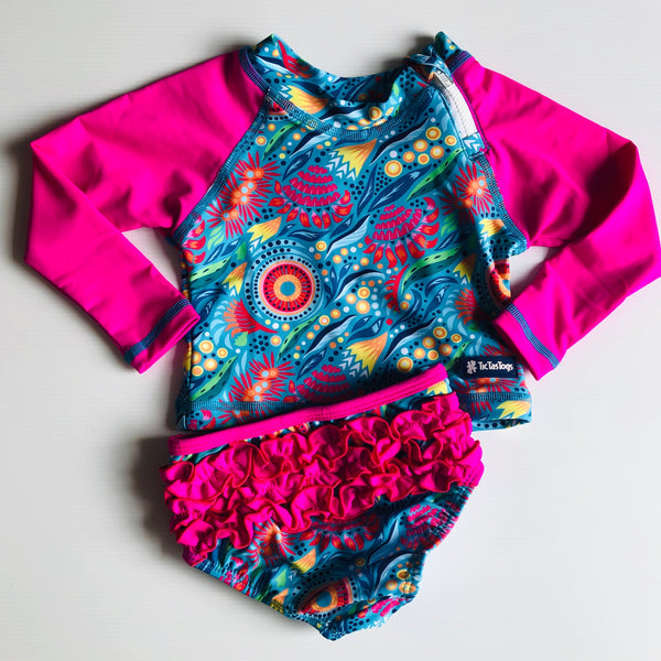 Colorful two piece children's swimsuit with pink long-sleeve rash guard and brief