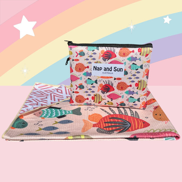 Nap and Sun Rainbow Reef sand-free beach towel for kids with a colorful underwater theme on the front, featuring vibrant coral, fish, and sea creatures on a light peachy background. Back: White background pink geometric lines. free matching wetbag included. 