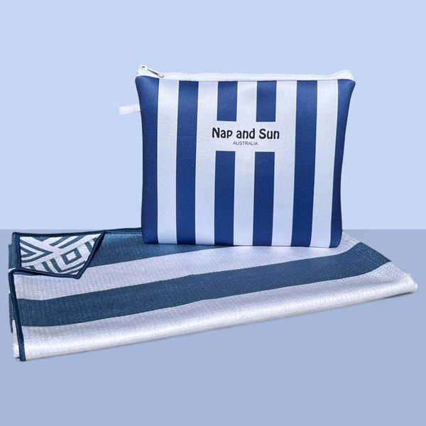 Nap and Sun Stripe Love sand-free beach towel featuring a double sided design. Front: bold, alternating navy blue and white horizontal stripes. Back: White background blue geometric lines. free matching wetbag included. 