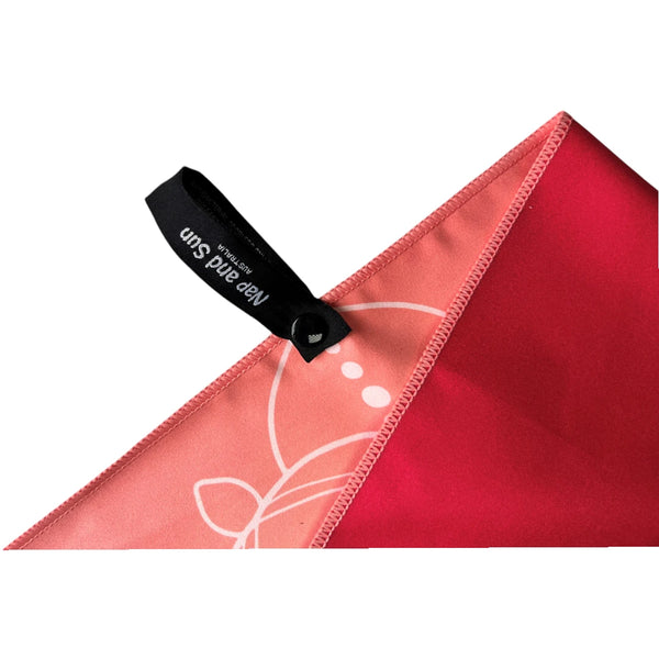 Close-up of balance gym towel with a pink mandala front , red back, and a black hanging loop with 'Nap and Sun Australia' text.