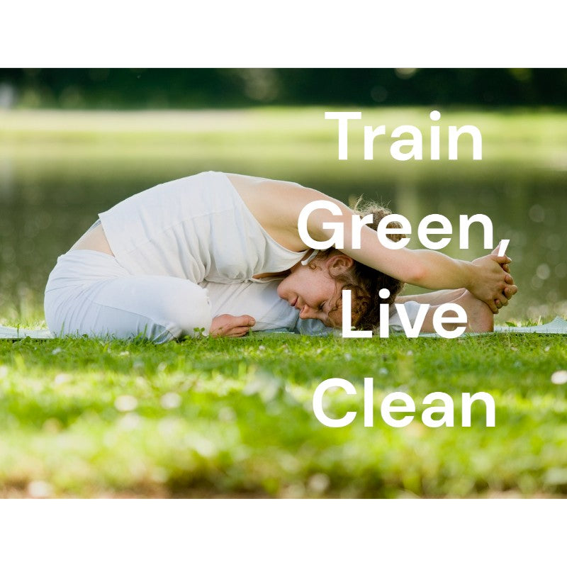 Woman in white clothing practicing yoga on the grass, bending and holding her extended leg. Text overlay: 'Train Green, Live Clean.