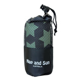 Green gym towel with black star pattern called 'Strength' stored in a black mesh bag with the Nap and Sun Australia logo on the bag.