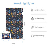 Kids-size Treasure Island, pirate theme towel displayed with matching neoprene wetbag. Text overlay highlights features: sand repellent, quick drying, lightweight, neoprene bag.