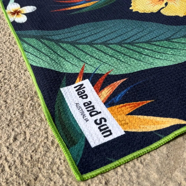 Close-up of the Tropical Bliss towel on the sand, showcasing its vibrant design and sand-free texture.