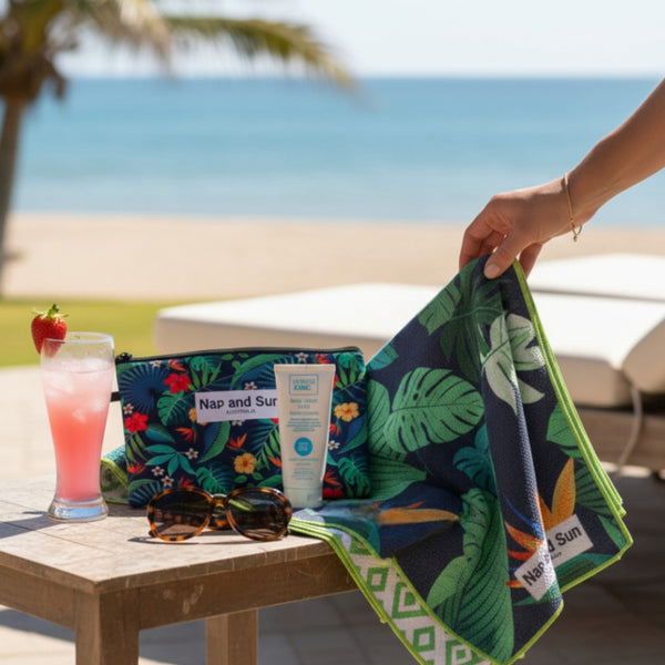 Tropical-themed towel with pouch, and drink on a table with a beach background.