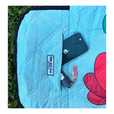 Close-up of a zip pocket on a picnic blanket with a phone and car key securely placed inside.