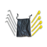 A black bag is placed beside four yellow plastic pegs and four steel pegs -for beachmats / picnic mats