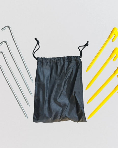 A small black bag is placed beside four yellow plastic pegs and four steel pegs, neatly arranged. Napandsun WindyCorner Picnic Pegs