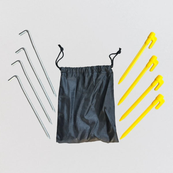 A small black bag is placed beside four yellow plastic pegs and four steel pegs, neatly arranged. Napandsun WindyCorner Picnic Pegs