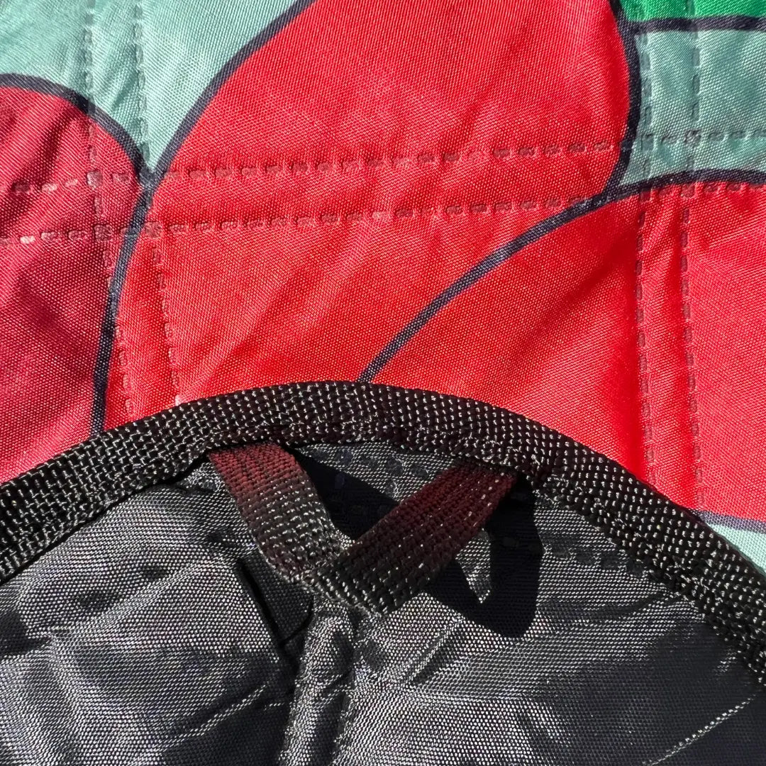 Close-up of the corner loop on the backside of a vivid meadow picnic blanket.