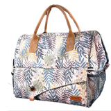 Floral patterned bag with brown handles and trim on a white background