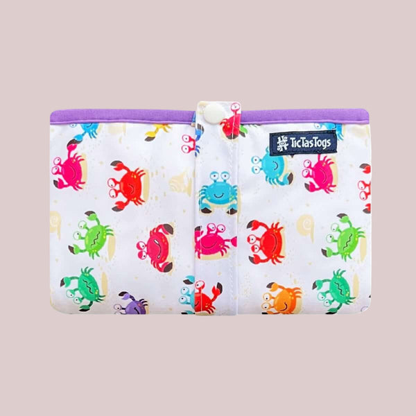 Colorful crab-patterned pouch with a visible brand logo on a beige background