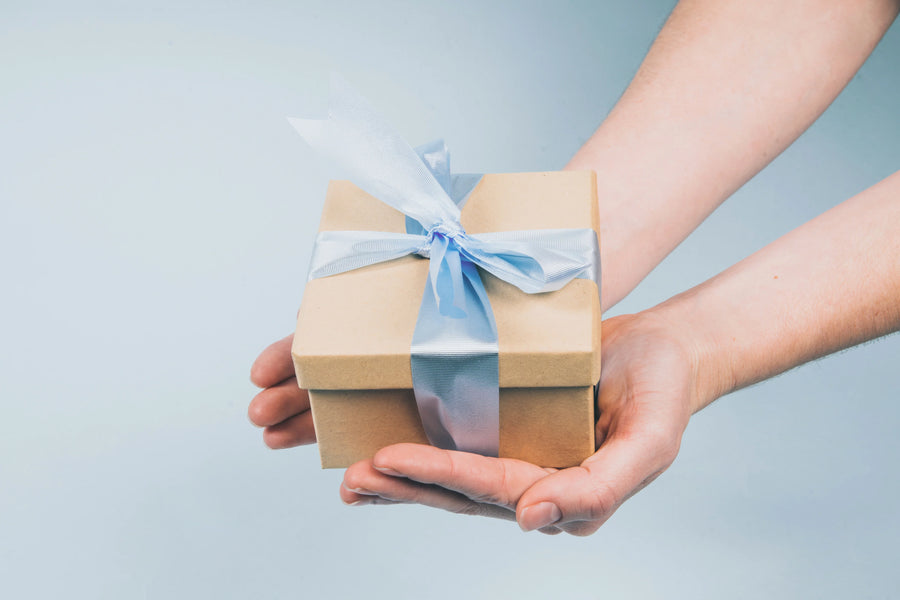 gift package in hand with a blue ribbon
