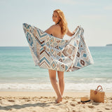 Woman on a beach holding an azure blue patterned towel