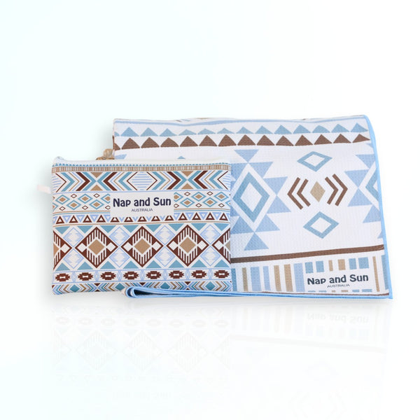 Nap and Sun Azure Tribe sand-free beach towel featuring a vibrant tribal pattern in shades of blue, white, and brown.  Free matching wetbag included. 