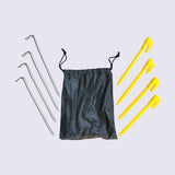 A black bag is placed beside four yellow plastic pegs and four steel pegs -for beachmats / picnic mats
