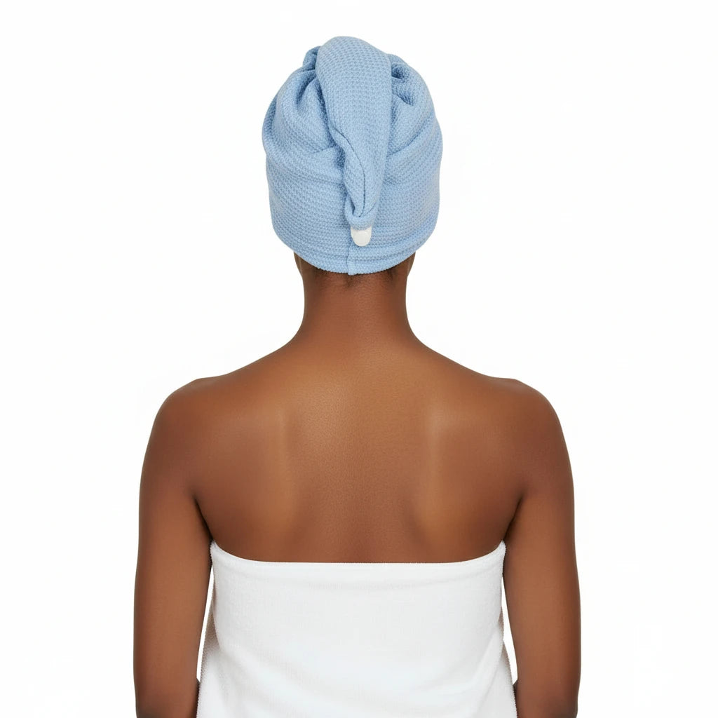Person with a blue towel wrapped around their head on a white background