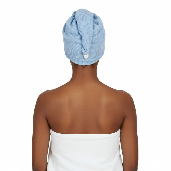 Person with a blue towel wrapped around their head on a white background