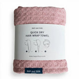 Pink hair wrap towel wrapped in a paper sleeve
