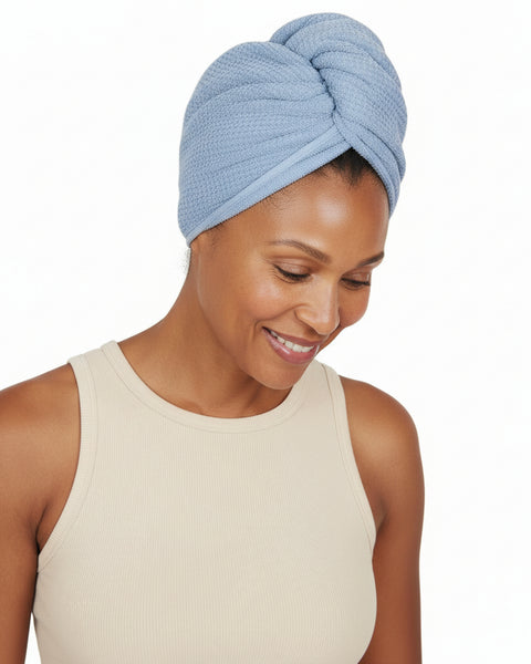 Woman wearing a blue textured head wrap on a white background