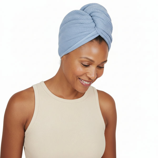 Woman wearing a blue textured head wrap on a white background