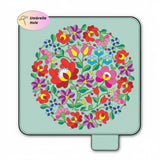 Colorful floral pattern picnic mat on a green background with an umbrella hole label.
