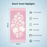 Pink floral-patterned beach towel with dimensions and features on a light blue background