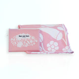 Nap and Sun Pink Bloom sand-free beach towel featuring a  soft pink background with white floral pattern. Free matching wetbag included. 