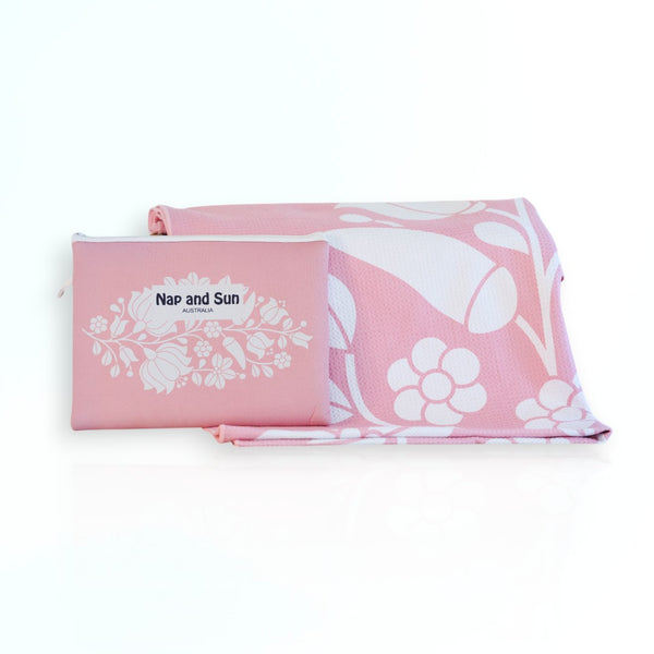 Nap and Sun Pink Bloom sand-free beach towel featuring a  soft pink background with white floral pattern. Free matching wetbag included. 