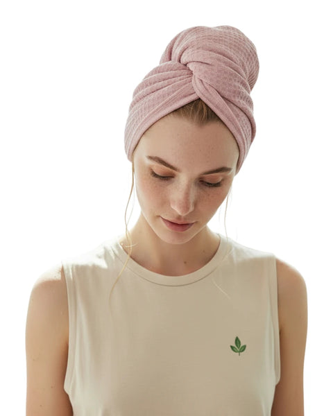 Woman wearing a pink towel turban on a white background
