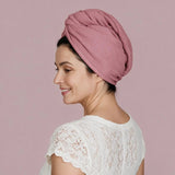 Woman wearing a dusty pink waffle wave hair wrap with a white lace top against a pink background.