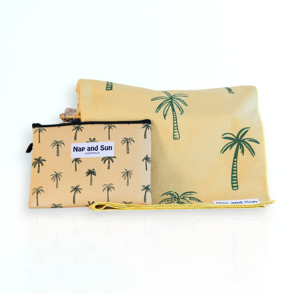 Napandsun Sunset Palms sand free beach towel featuring medium size palm trees on a yellow/goldish background. Free wetbag included. 