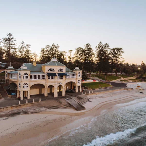 Large building on a beach with trees in the background