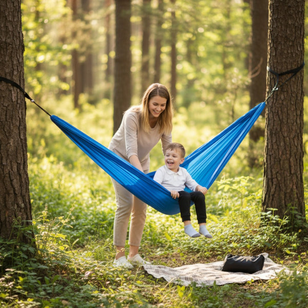 Woman and child in a blue hammock in a forest setting